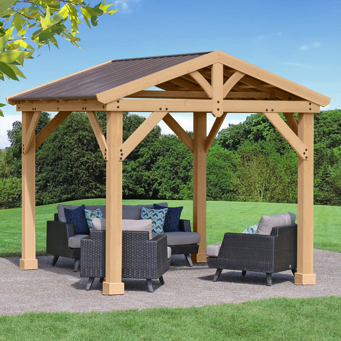 Fully assembled Meridian Cedar 10x10 Pavilion in a garden setting with outdoor furniture under its shelter.