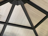  Inside view of a 10x10 Venus Gazebo roof with beige privacy curtains between the black metal framework, creating a geometric pattern.
