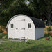 Little Cottage Co. 10x12 Round Roof Chicken Coop in white with black shingles, shown outdoors with chickens in a green grassy backyard.