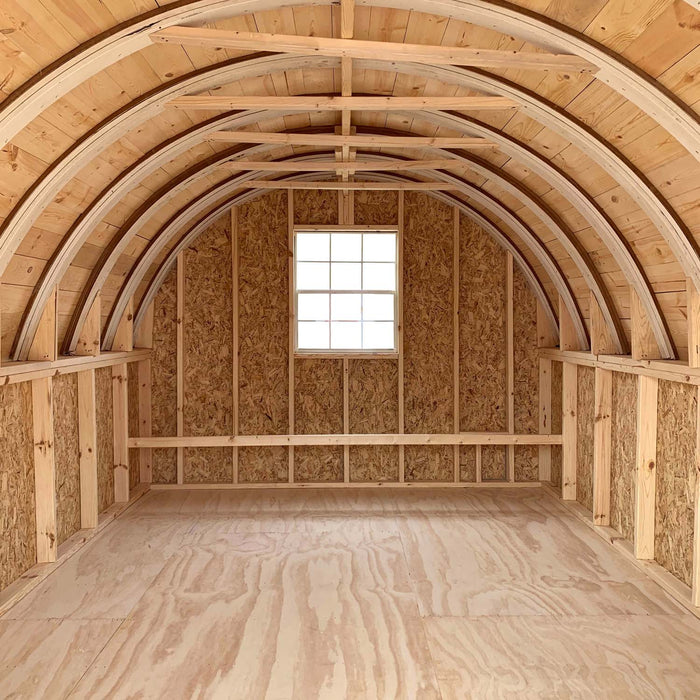 View from inside the 10x16 Little Cottage Co. Round Roof Coop, showing a centered window, wooden framing, and smooth plywood flooring.