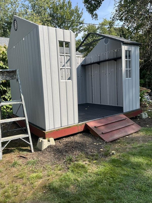 Lifetime 10x8 ft. storage shed during assembly, showing the open frame and roof structure before completion.