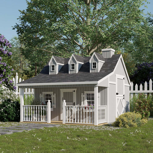 Gray Little Cottage Co. 11x10 Pennfield Cottage Playhouse featuring three dormer windows, white trim, Dutch door, and front porch set in a lush fenced yard.