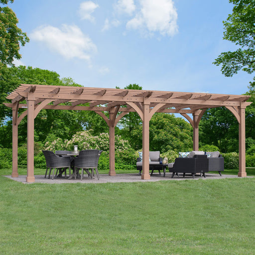 Fully assembled Yardistry Cedar 12x24 Pergola in a garden setting with outdoor furniture under its shelter.