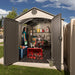 Interior view of the Lifetime 15x8 ft. storage shed with open door showing a mower, snowblower, and shelving.