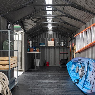 Interior of the Lifetime 20x8 ft. storage shed with shelving, a ladder, storage crates, and a kayak.
