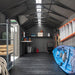 Interior of the Lifetime 20x8 ft. storage shed with shelving, a ladder, storage crates, and a kayak.