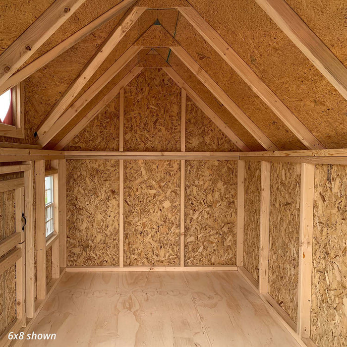 Interior of the 6x8 Victorian Playhouse showing unfinished wood framing, pitched ceiling, and natural plywood walls ready for customization.