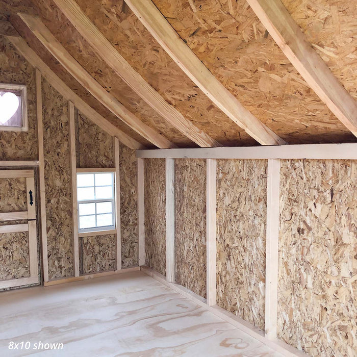 Angled view of the 8x10 Gingerbread Cottage Playhouse interior highlighting wood framing, heart window, and OSB paneling for durable structure.