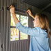 Interior view of the Lifetime storage shed's window frame with a person measuring for installation.