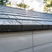 Close-up of the Lifetime storage shed's roof shingle edge detail with water droplets.