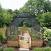 Front view of the 8x16 Garden in a Box with Birdnetting Cover, cedar gate open onto the gravel path with greens and marigolds under the net