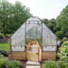 Front view of the 8x16 Greenhouse Garden in a Box, clear canopy over western red cedar beds with the gate open to a gravel center walkway