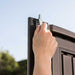 Close-up of a hand installing the Lifetime storage shed's steel door hinge pin.