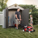 Man and daughter with a lawn mower next to the Lifetime 8x5 ft. storage shed with open doors.