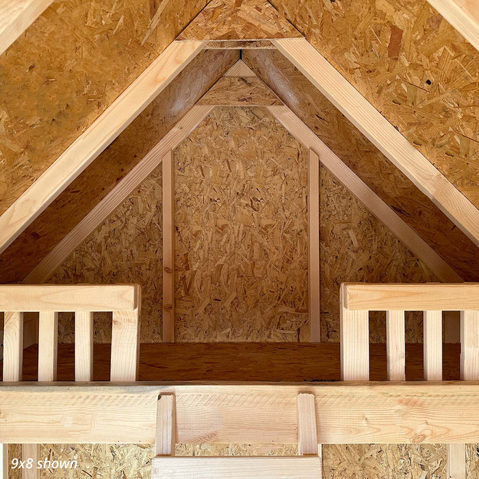Inside the 9x8 Pennfield Cottage Playhouse, showing framed windows, open doorway to the porch, and exposed wood structure for a warm, rustic finish.