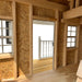 Interior view of the 9x8 Pennfield Cottage Playhouse showing wood framing, upper loft area, and detailed ceiling beams made of natural plywood.