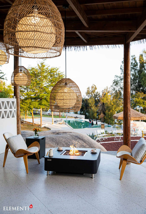  A cozy patio featuring the Elementi Plus Copenhagen Marble Porcelain Fire Table surrounded by comfortable chairs