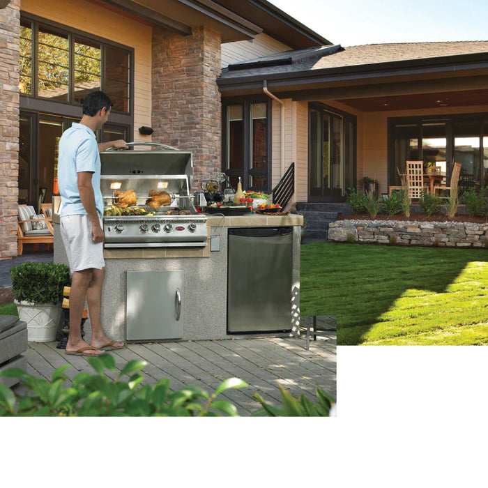 A person standing in front of the convection grill with food on top, outside a house