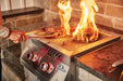 The Napoleon Grills Burner in action, showing steaks grilling with intense flames rising around them.