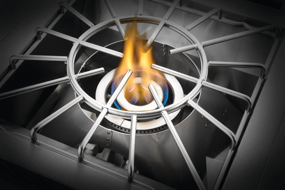 The Napoleon Grills Burner in operation, with a cooking grate in place and a blue flame encircling the burner.