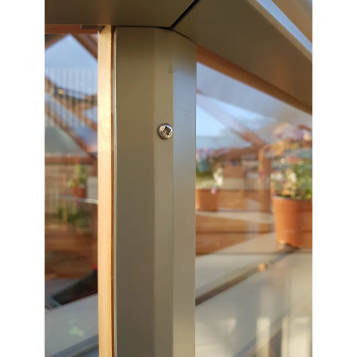 A detailed view of the Alton Cedar Octagonal Greenhouse Accessories reveals glass panels, screws, and bar capping, with an outdoor area featuring potted plants in the background.