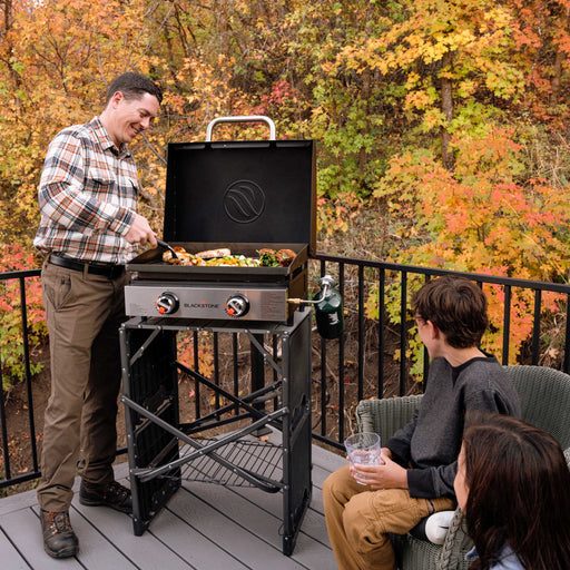 A family gathered around the stainless tabletop grill