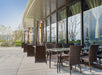 A commercial setting featuring the Vesta Flame Tower Heater on a restaurant's outdoor patio, providing a warm welcome to patrons.