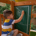 A kid writing on the board of the outdoor swing set