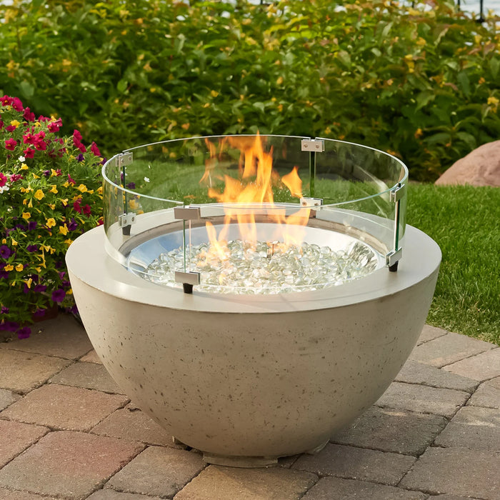  The Outdoor Greatroom Co Cove Round 29-inch gas fire pit bowl with a glass wind guard on a patio setting.