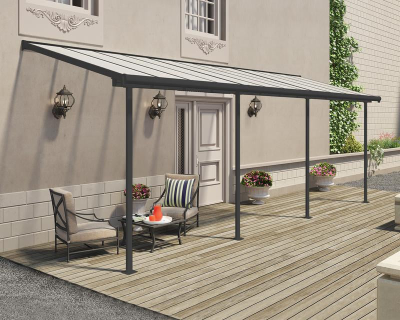 Outdoor lifestyle setting featuring Canopia Sierra 7.5' x 22' Patio Cover - Grey/Clear, shading an extended seating area on a patio.