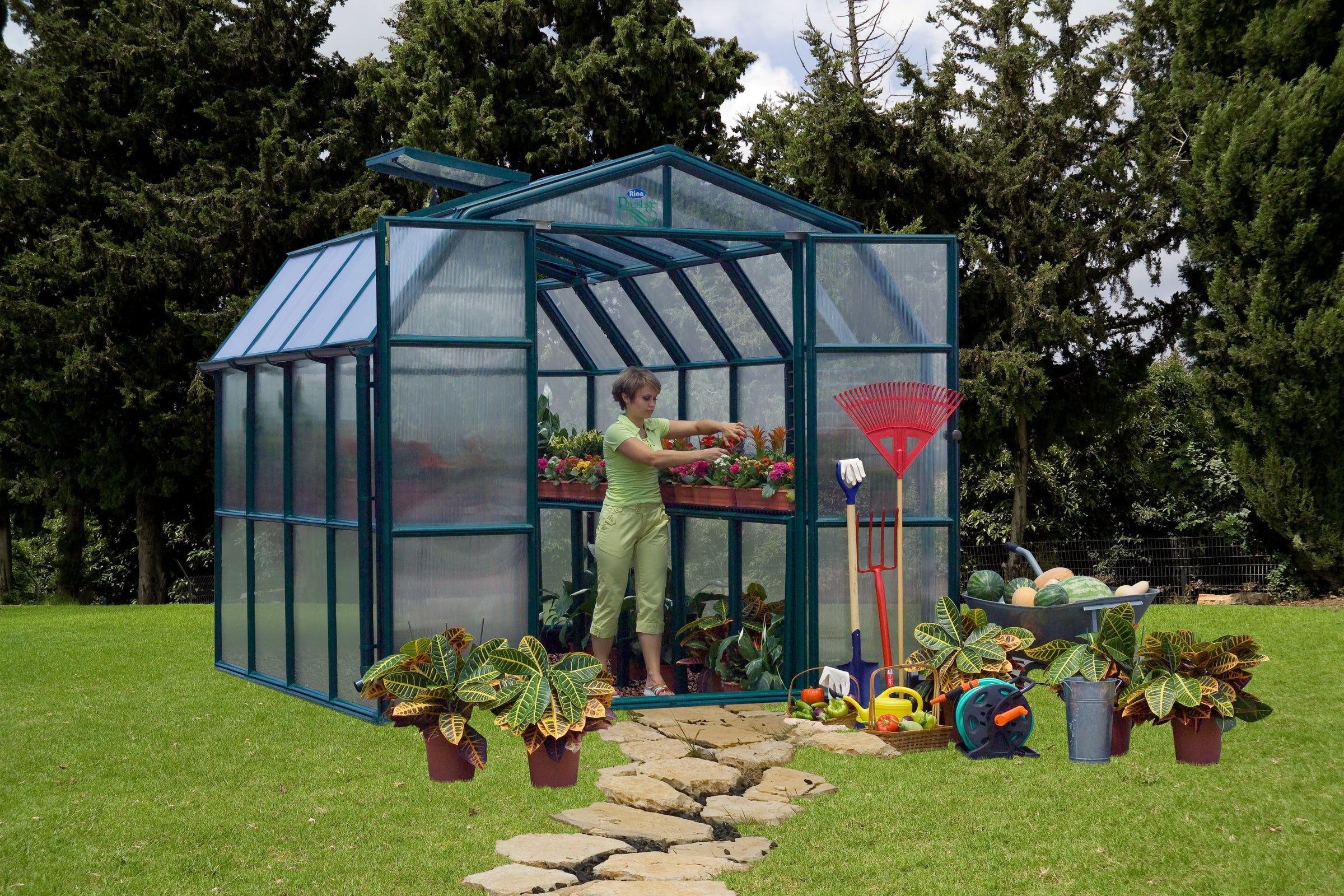 an actual product image of the Canopia Prestige 8' Greenhouse - Twin Wall with a woman inside tending to her plants