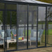 Exterior view of the Canopia SanRemo 13' x 14' Patio Enclosure showcasing the gray frame and clear panels, integrated within a garden setting.