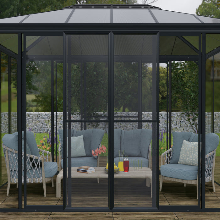 View of the Canopia SanRemo 13' x 14' Patio Enclosure showing the interior with wicker furniture and cushions, set on a wooden deck against a natural backdrop.