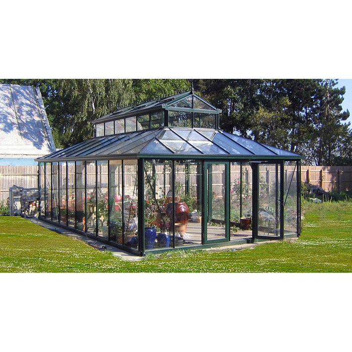 A well-lit 15x20 ft cathedral Victorian greenhouse with large cupola, showcasing transparent glass panels and situated on green grass.