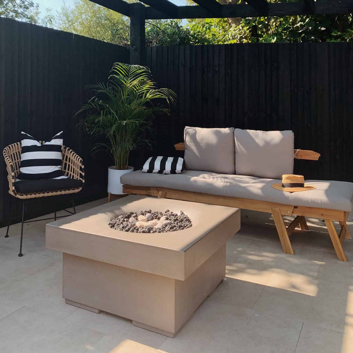 A chic urban backyard space featuring an elevated Halo fire table, blending seamlessly with the modern outdoor furniture.