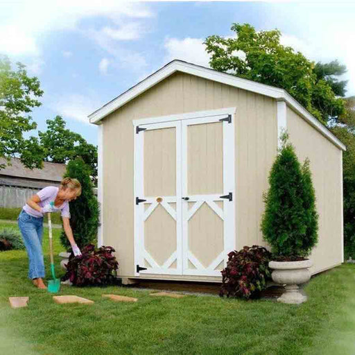 A woman gardening next to the beige Classic Gable Shed by Little Cottage Company, featuring white trim and double doors.