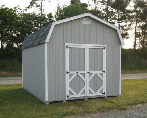 A stand-alone grey Classic Gambrel Barn with white trim and double doors by Little Cottage Company, set against a dusky sky.