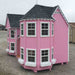 Close-up of Little Cottage Company Sara's Victorian Mansion Playhouse in pink