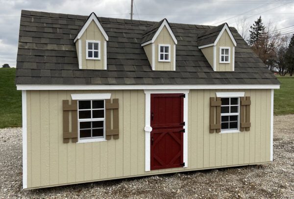 A sturdy Cape Cod Playhouse from Little Cottage Company featuring a red door and shutters with beige siding and a dark roof.