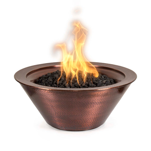 Flames dance within The Outdoor Plus Round Cazo Hammered Copper Fire Bowl, showcasing its textured finish and warm glow,in white background