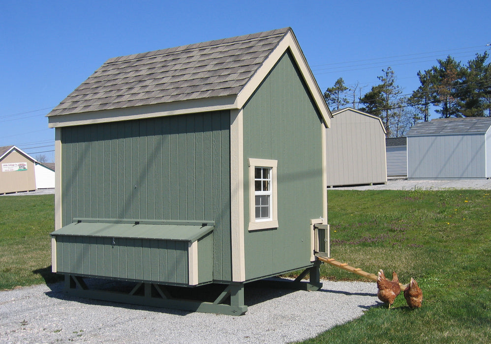 Outdoor view of a Colonial Gable Chicken Coop by Little Cottage Company, complete with free-range chickens entering the coop ramp.