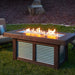 The Fire Pit Table in operation during the evening, with visible flames and nearby outdoor furniture.