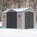 A Duramax Apex Pro PLUS 10.5 x 8 Garden Shed in beige and gray color, sitting in a snowy landscape.