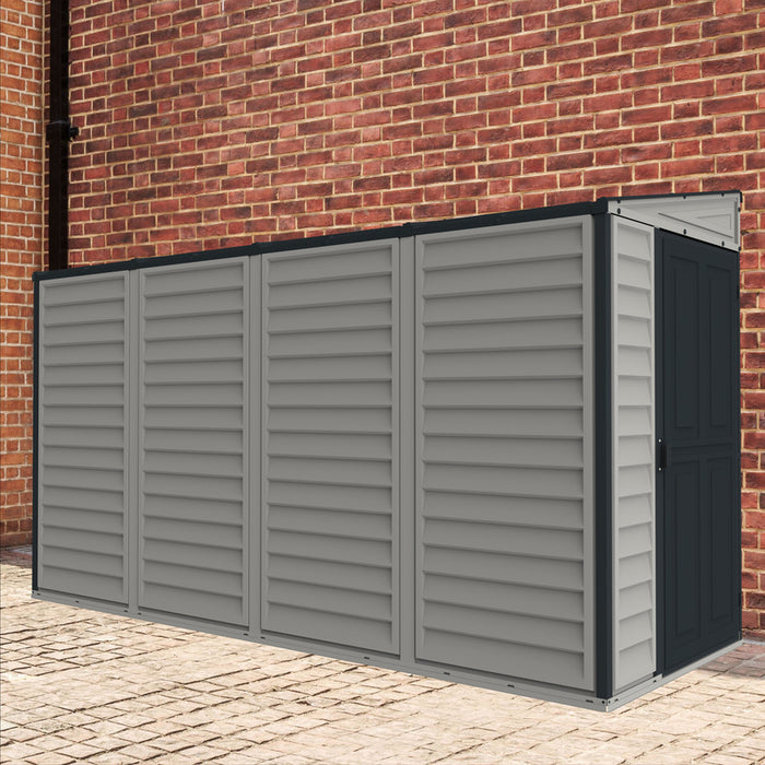 Duramax Sidemate Plus 4'x10' vinyl resin shed positioned against a brick wall on a paved surface, displaying its compatibility with urban outdoor settings and showcasing the dark gray door.
