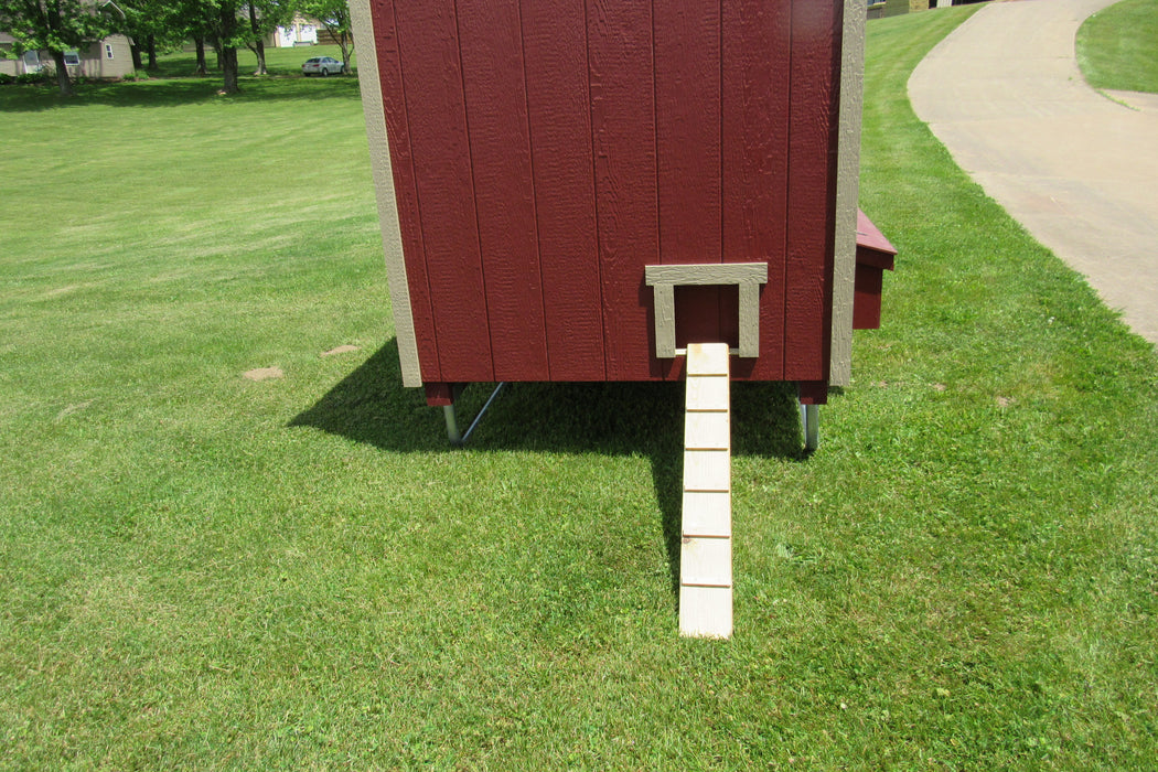 5x8 EZ-Fit chicken coop equipped with a wooden ramp for chicken accessibility, set against a green lawn backdrop.