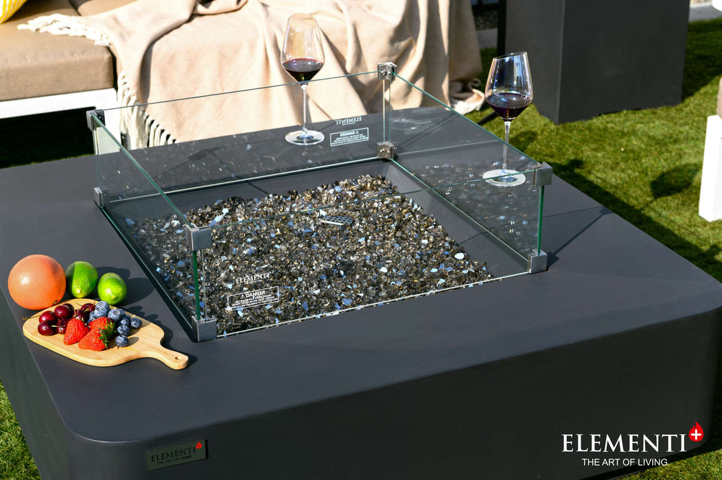 Two wine glasses and an assortment of fruit, showcasing the elegant Bergamo Fire Pit Table with Fire Glass