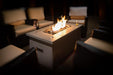Intimate evening ambiance created by the Solus Firetable, paired with wine glasses for a relaxing outdoor experience.