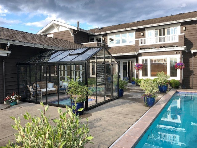 A poolside setting enhanced by the presence of an Exaco Victorian VI-34 Royal greenhouse, blending luxury with horticulture.