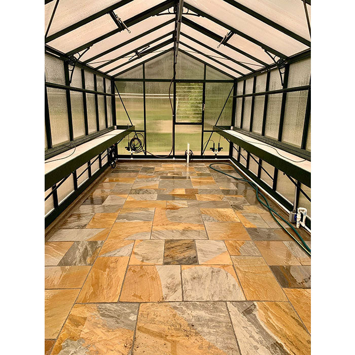 Elegant interior of the Exaco Janssens Royal Victorian VI 46 Greenhouse featuring natural stone flooring and practical shelving, ready for nurturing a diverse collection of plants.