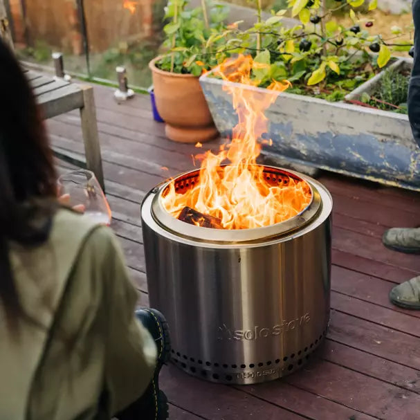 Lit Bonfire Fire Pit with Stand 2.0 on a wooden deck.